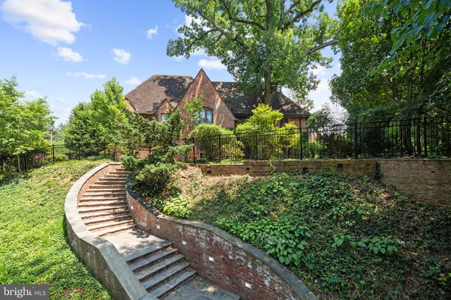 a view of a house with a yard and a large tree