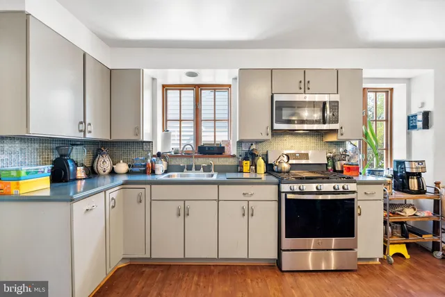a kitchen with stainless steel appliances a stove a sink and a microwave