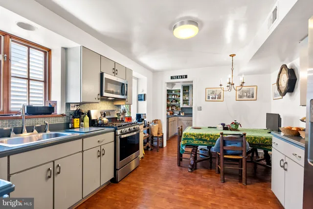 a kitchen with cabinets and chairs