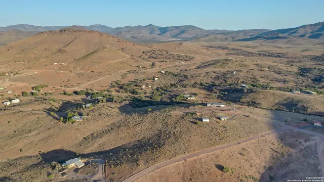 a view of a dry yard with mountains in the background