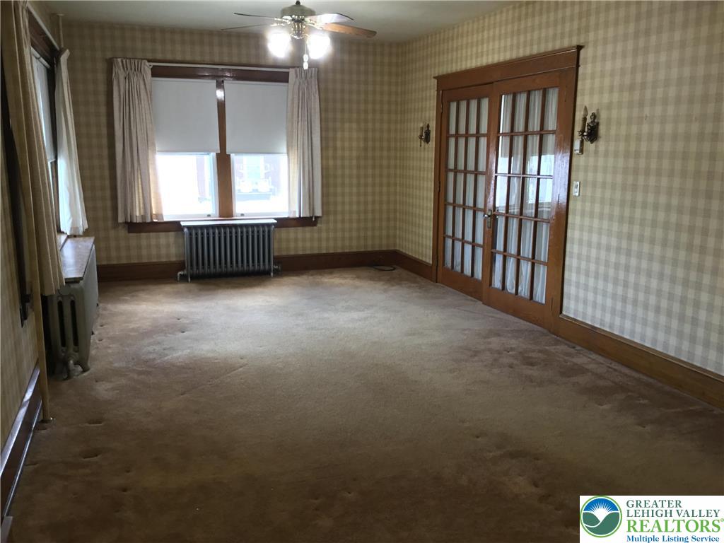 1105 Main Street Slatington, PA 18080 - Photo 7 of 31 Sun-filled room featuring wood-trimmed French doors and comfortable carpeting, awaiting a personal touch.