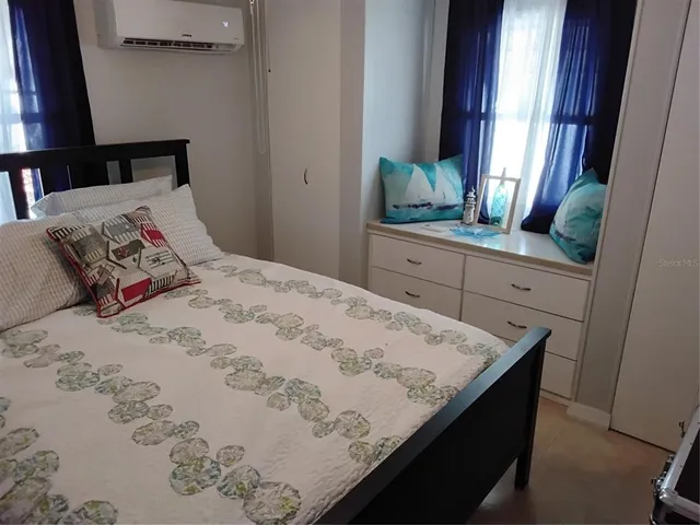 a bedroom with a bed and a mirror on dresser
