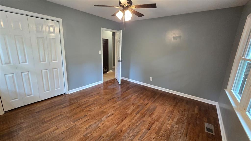 700 New Street Eatonton, GA 31024 - Photo 13 of 19 an empty room with wooden floor fan and windows