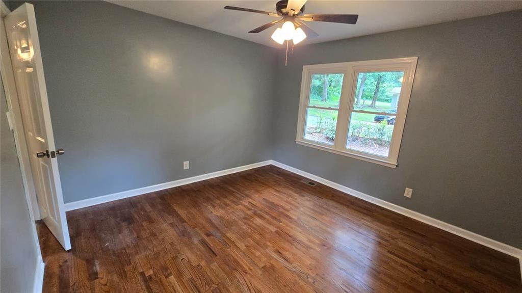 700 New Street Eatonton, GA 31024 - Photo 14 of 19 an empty room with wooden floor fan and windows