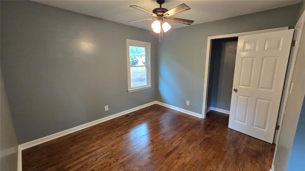 700 New Street Eatonton, GA 31024 - Photo 16 of 19 an empty room with wooden floor closet and windows