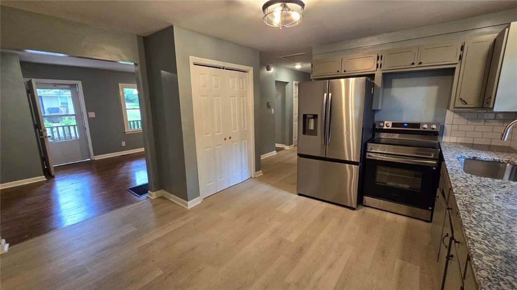700 New Street Eatonton, GA 31024 - Photo 9 of 19 a kitchen with granite countertop a refrigerator and a stove top oven
