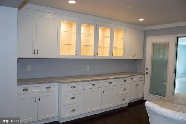 a kitchen with white cabinets and a window