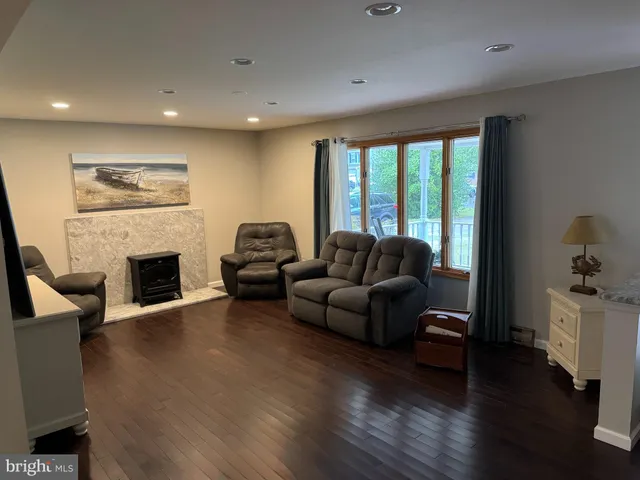 a living room with furniture a fireplace and a large window