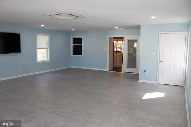 an empty room with windows and fireplace