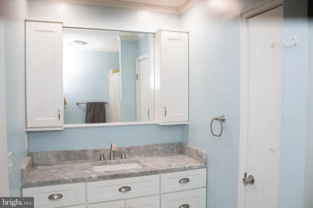 a bathroom with a granite countertop sink and a mirror