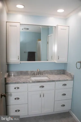 a bathroom with a granite countertop sink and a mirror