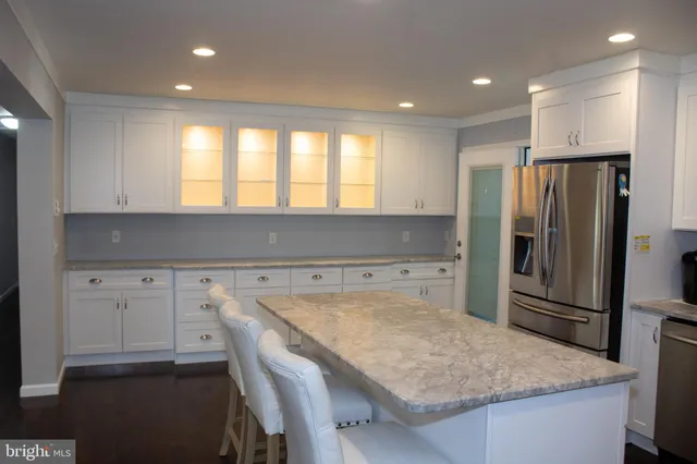 a kitchen with a table chairs refrigerator and microwave