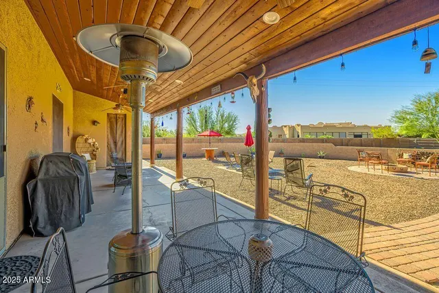 a view of house with swimming pool outdoor seating and house in the background