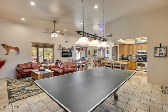 a living room with furniture a flat screen tv and kitchen view