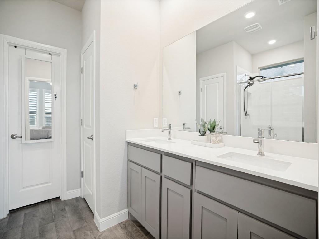 1612 Reed Drive Krum, TX 76249 - Photo 16 of 25 Bathroom featuring a dual vanity with undermount sinks, light gray cabinetry, and a large mirror