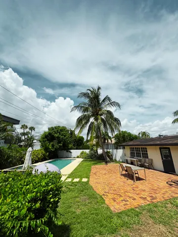 a view of a swimming pool with lawn chairs under an umbrella