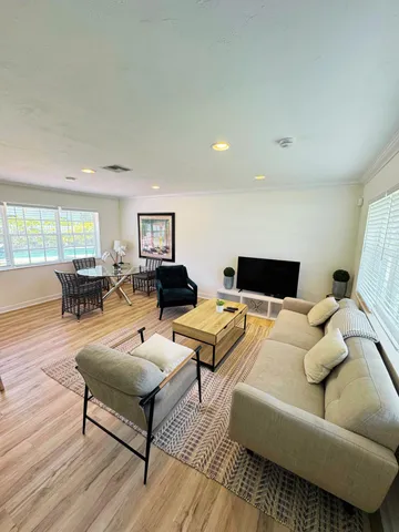 a living room with furniture and wooden floor
