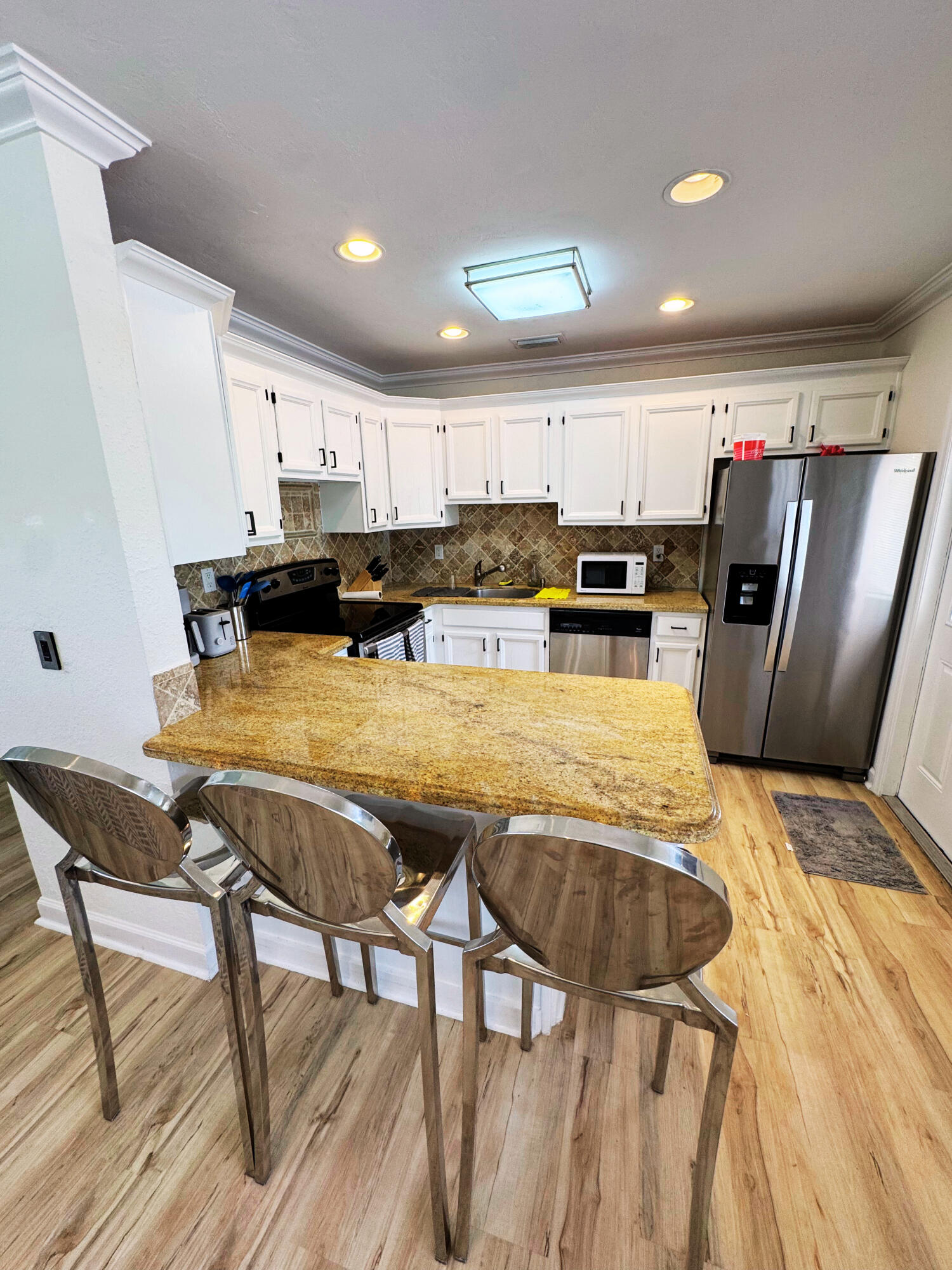 300 Northeast 7th Street Boca Raton, FL 33432 - Photo 4 of 16 a kitchen with stainless steel appliances granite countertop a table chairs sink and cabinets