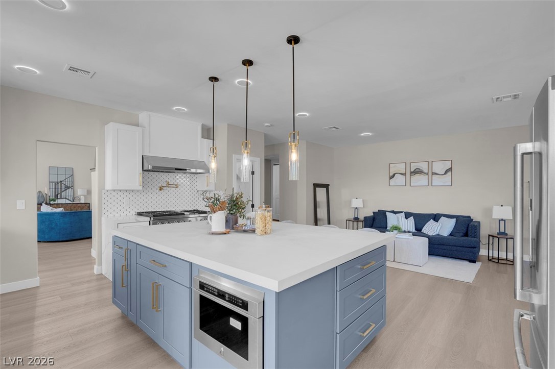 8848 Rainbow Ridge Drive Las Vegas, NV 89117 - Photo 4 of 43 A contemporary kitchen boasts a spacious island and seamlessly connects to a living area.