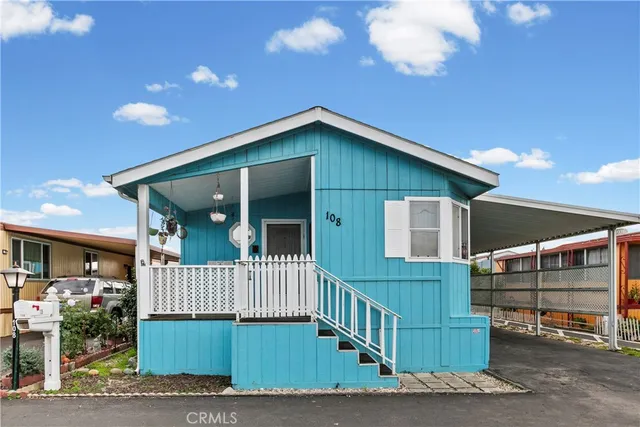 a view of a house with a small yard and wooden fence