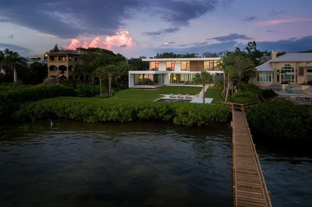 a front view of a house with garden and a tree