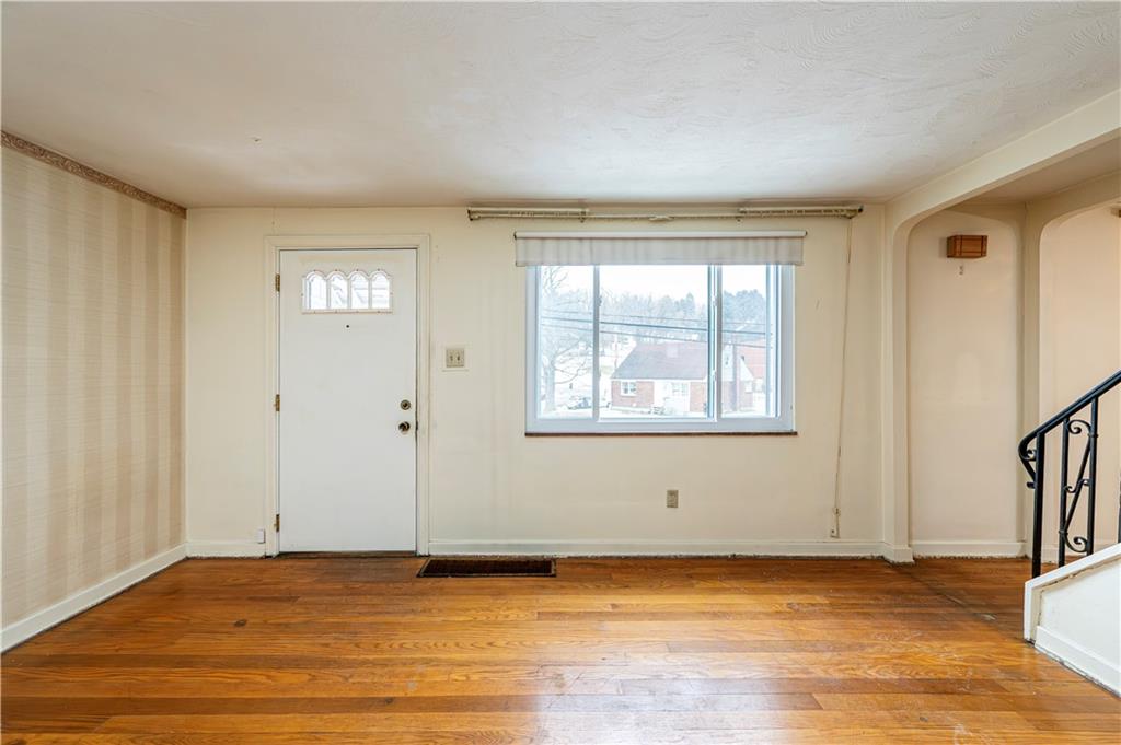 523 Beulah Road Pittsburgh, PA 15235 - Photo 7 of 36 a view of an empty room with window and wooden floor