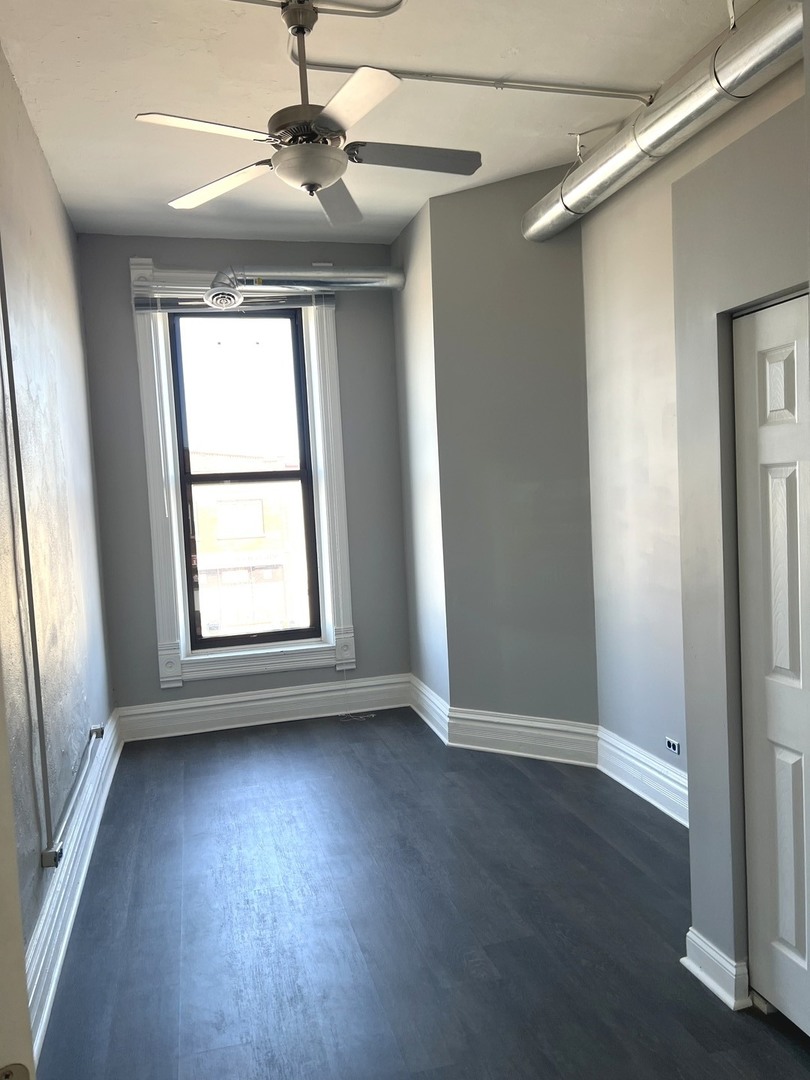 8 North State Street Elgin, IL 60123 - Photo 5 of 9 an empty room with wooden floor fan and windows