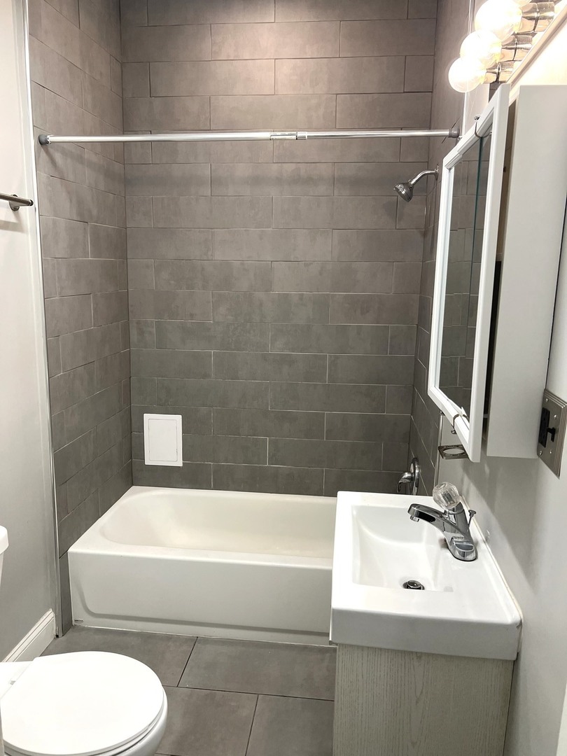 8 North State Street Elgin, IL 60123 - Photo 7 of 9 a bathroom with a sink toilet and shower