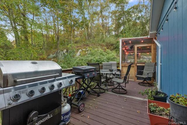 a view of a patio with table and chairs with wooden floor and fence