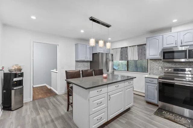 a kitchen with a sink dishwasher a stove and a refrigerator with wooden floor