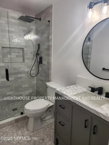 a bathroom with a granite countertop toilet sink and shower