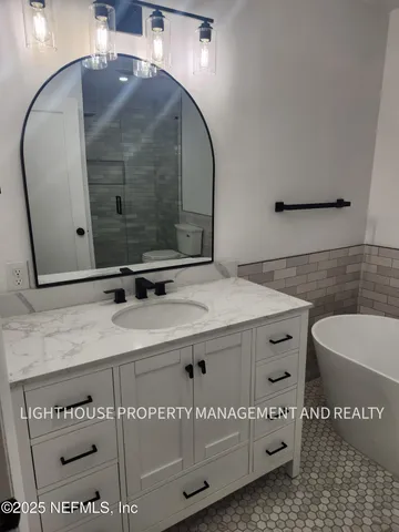 a bathroom with a sink a toilet and mirror