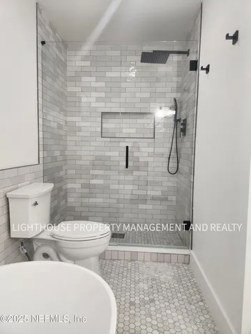 a bathroom with a toilet and a shower