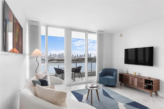 a living room with furniture a flat screen tv and a floor to ceiling window
