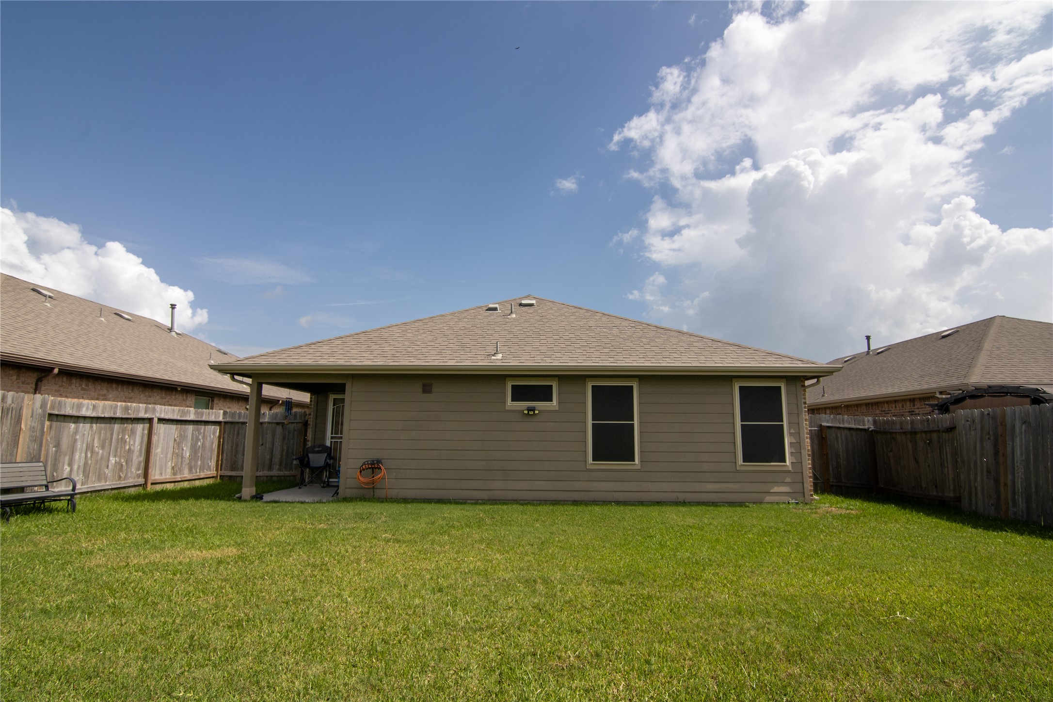 706 Zinnia Court Rosharon, TX 77583 - Photo 13 of 13 This photo shows the backyard of this single-story home with a fenced yard and a covered patio area, ideal for outdoor relaxation.