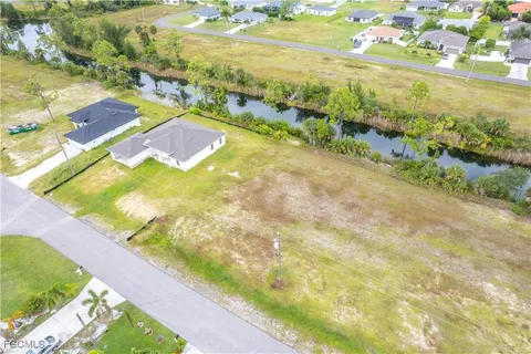 a swimming pool with lawn chairs and large trees