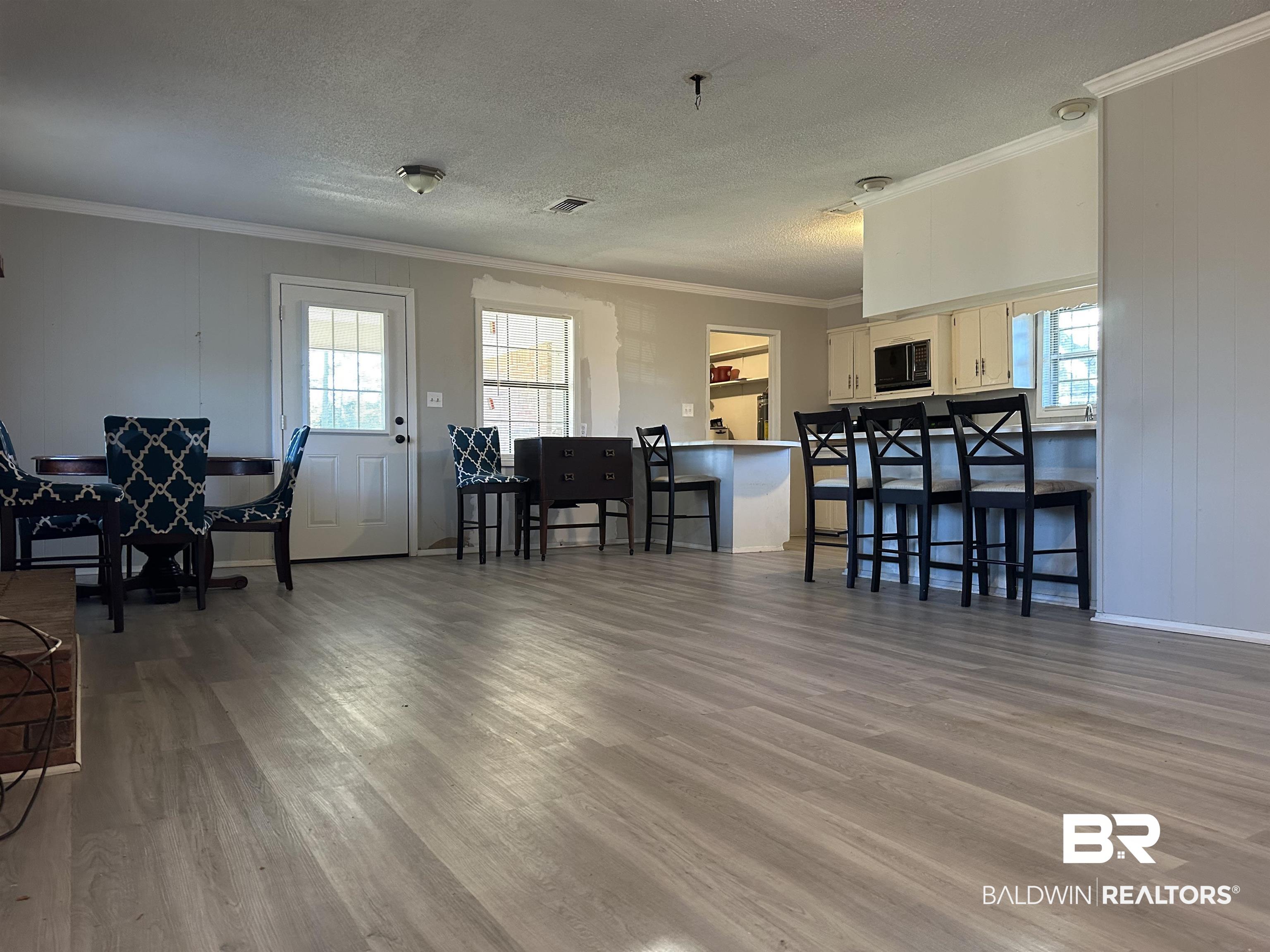 3451 Kirkland Road Brewton, AL 36426 - Photo 4 of 17 Living room with crown molding, a textured ceiling, and hardwood / wood-style flooring