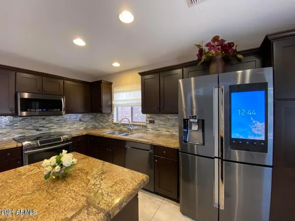 a kitchen with stainless steel appliances granite countertop a sink and a refrigerator