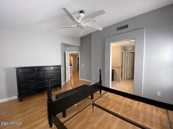 a living room with a piano and wooden floor