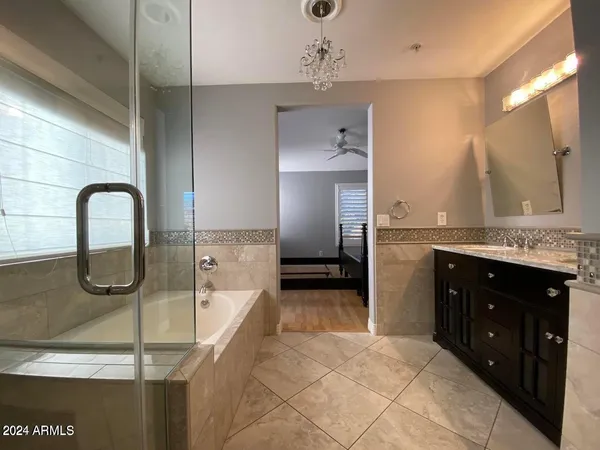 a spacious bathroom with a granite countertop sink a mirror and shower