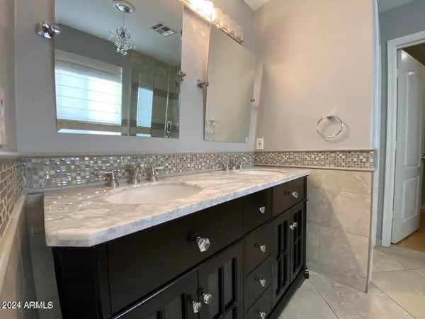 a bathroom with a granite countertop sink vanity and a mirror