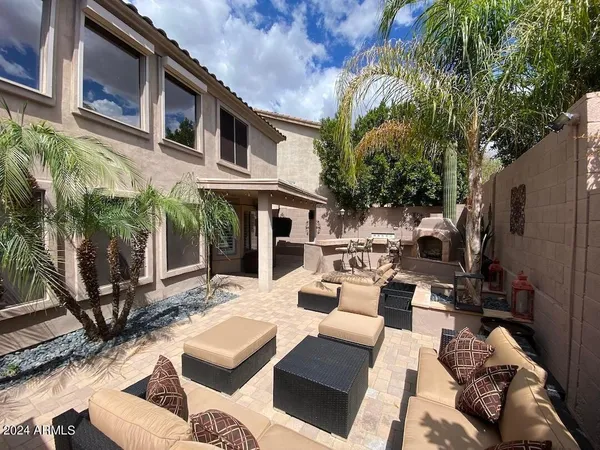 a view of a patio with couches table and chairs and potted plants
