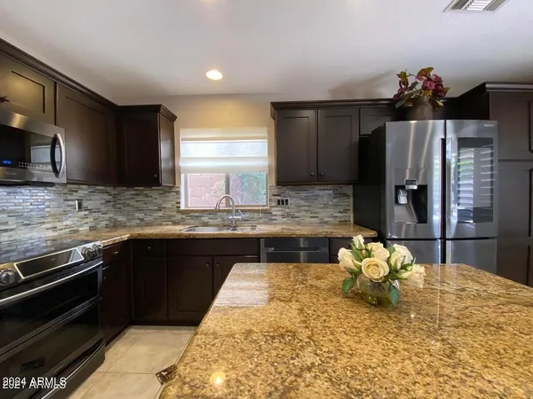 a kitchen with kitchen island granite countertop a refrigerator stove and sink