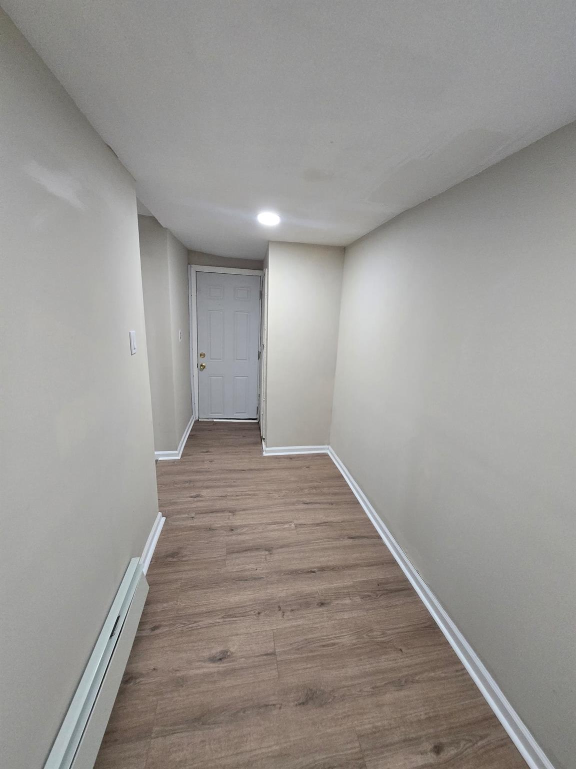 35-14 109th Street Queens, NY 11368 - Photo 29 of 38 Hall with baseboards, baseboard heating, and wood finished floors