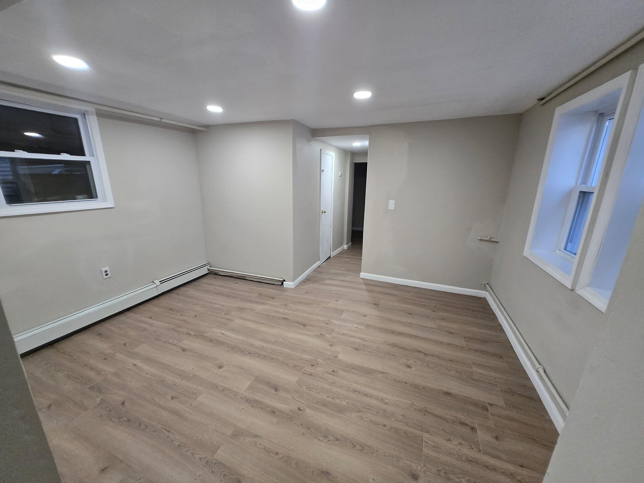 35-14 109th Street Queens, NY 11368 - Photo 30 of 38 Finished basement with baseboard heating, baseboards, light wood-style floors, and recessed lighting