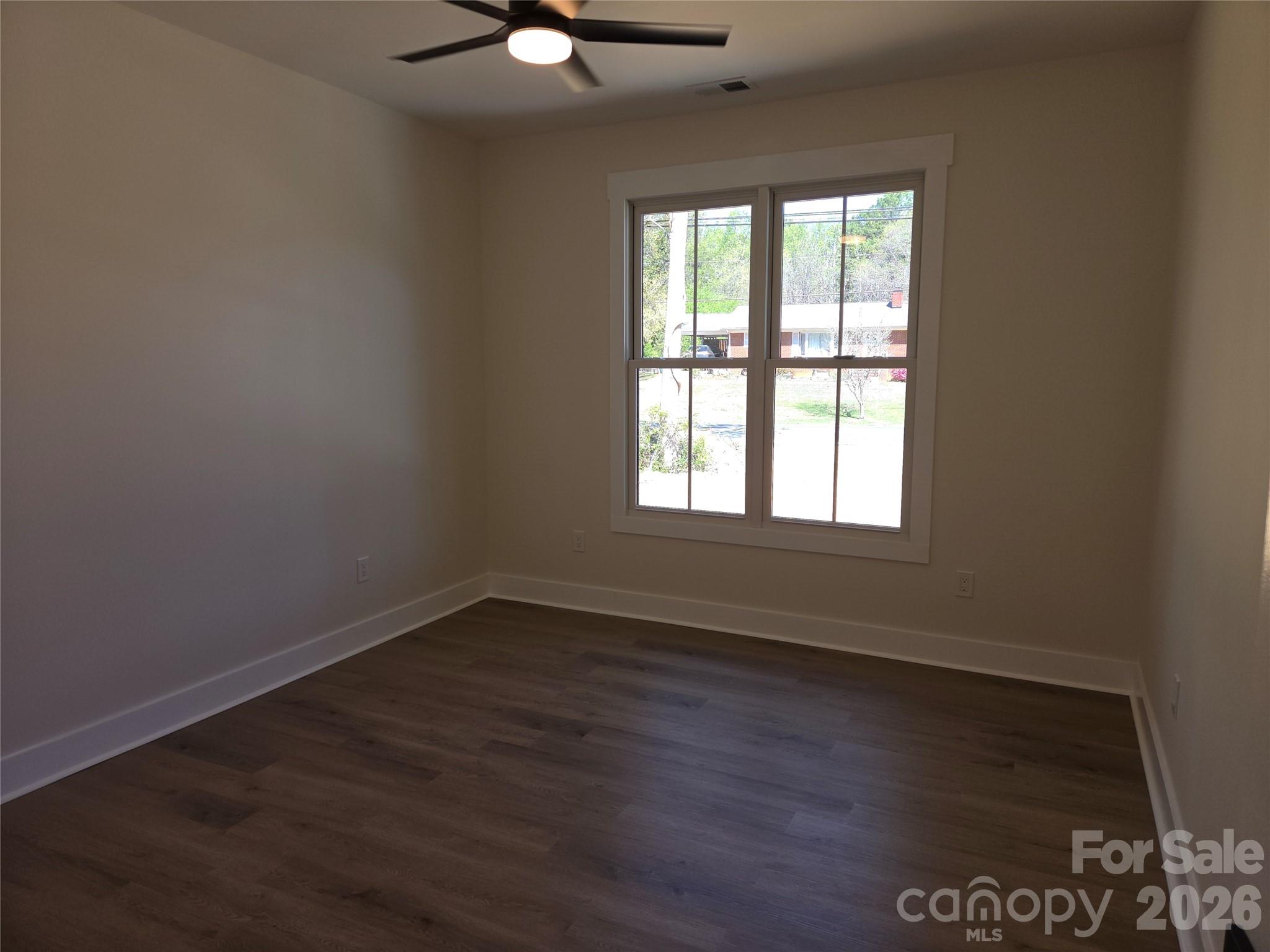 613 Bethany Road Albemarle, NC 28001 - Photo 15 of 26 an empty room with wooden floor and windows