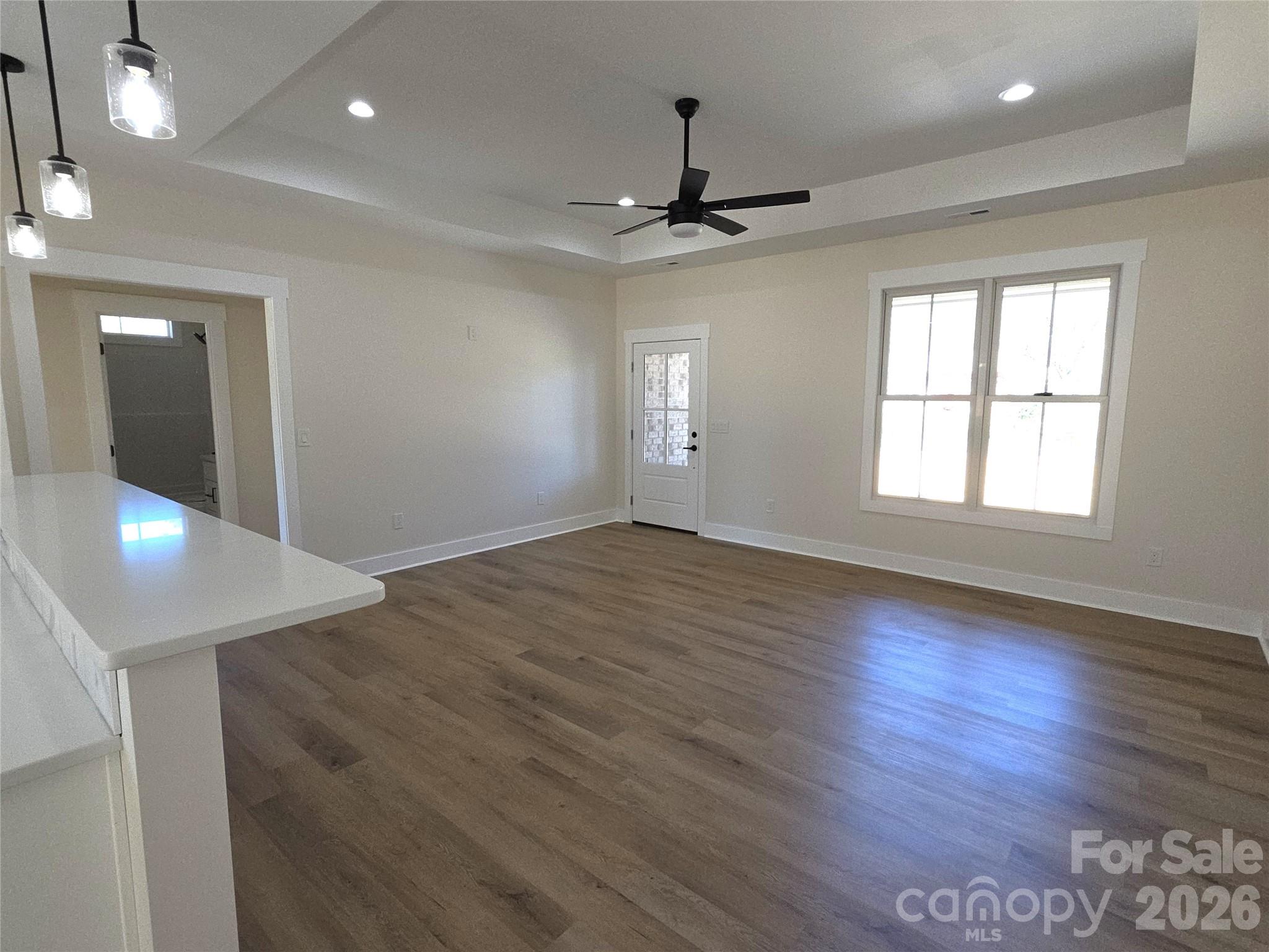 613 Bethany Road Albemarle, NC 28001 - Photo 4 of 26 an empty room with wooden floor and windows