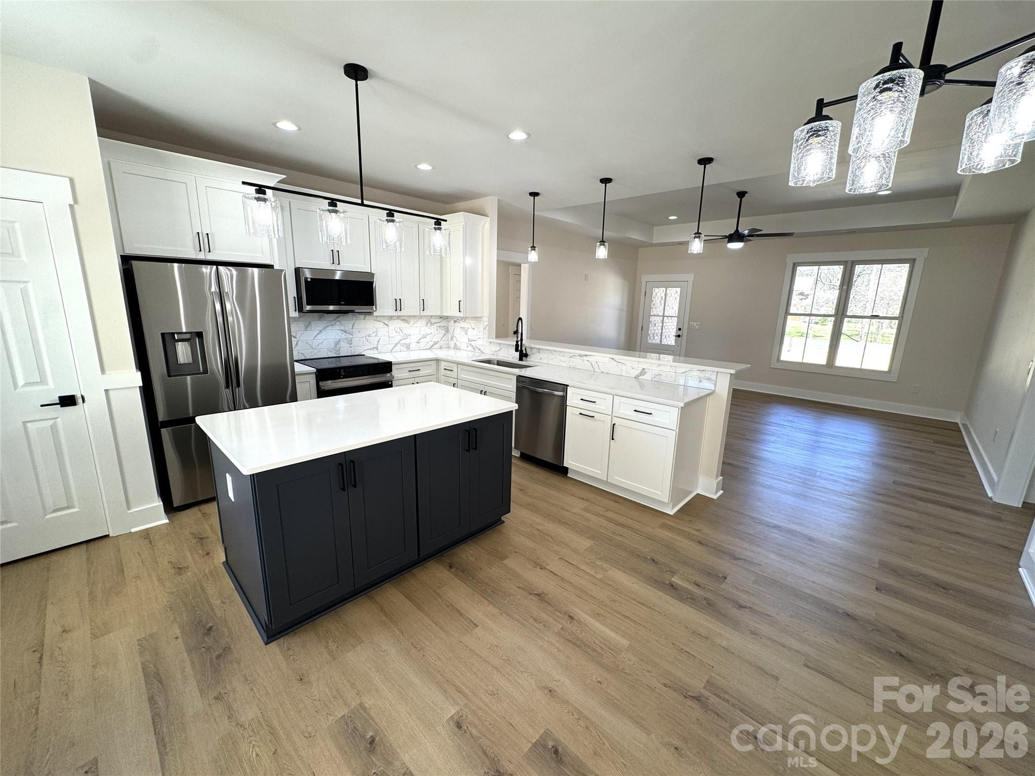 613 Bethany Road Albemarle, NC 28001 - Photo 8 of 26 a kitchen with wooden floors and white cabinets