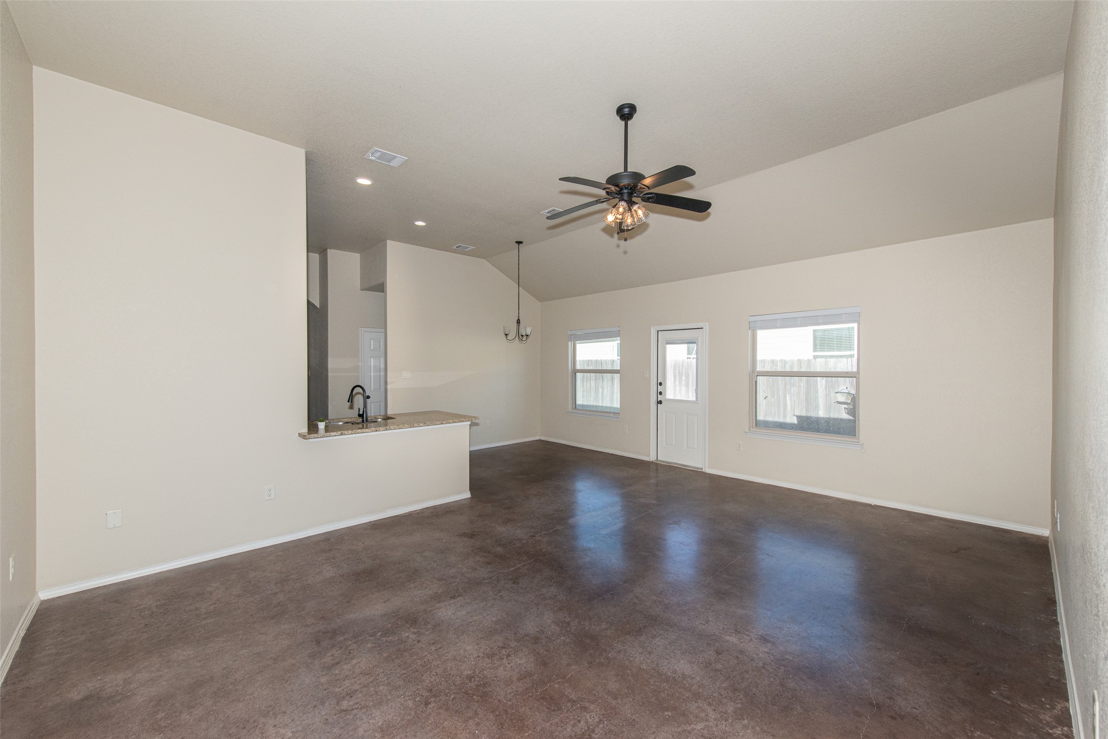 245 Joanne Loop, Unit B Buda, TX 78610 - Photo 2 of 33 Facing from entry to main living area, stained concrete, high ceilings, recessed lighting and ceiling fans