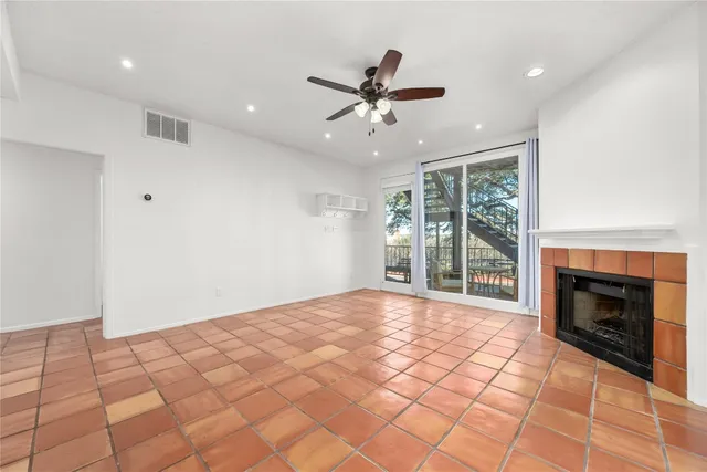 a view of an empty room with a fireplace and a window